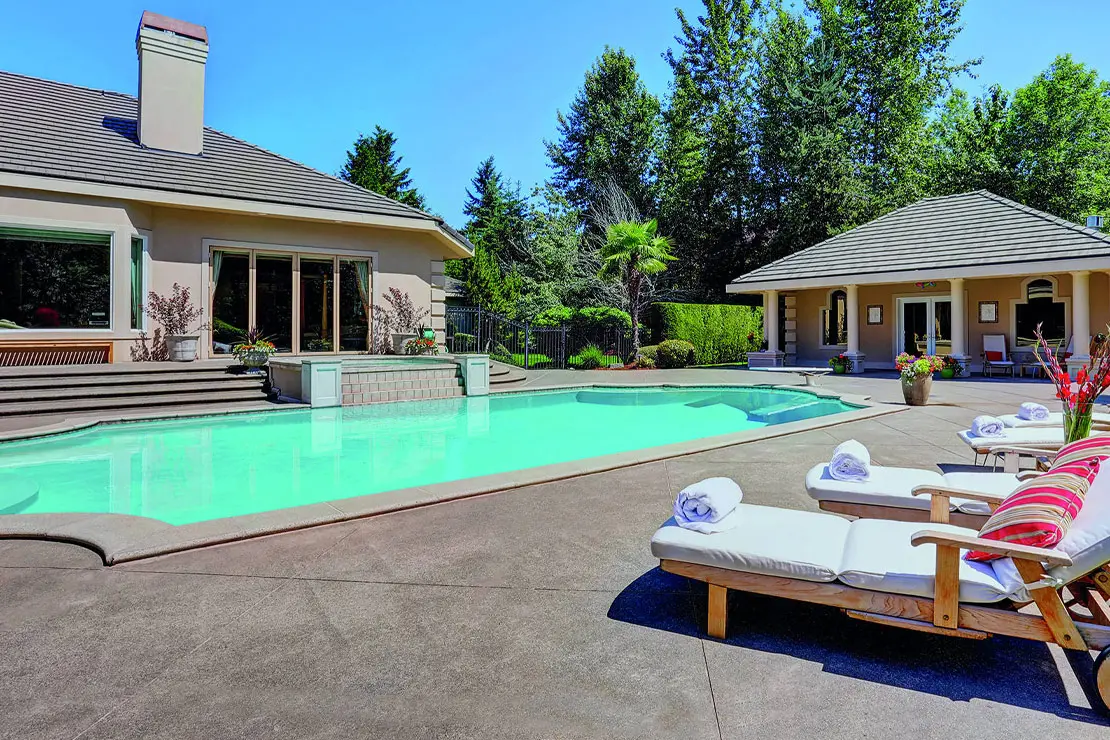 Casa con impresionante piscina alicatada con hormigón impreso.